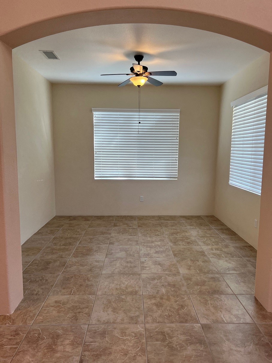 an empty room with a ceiling fan and a window
